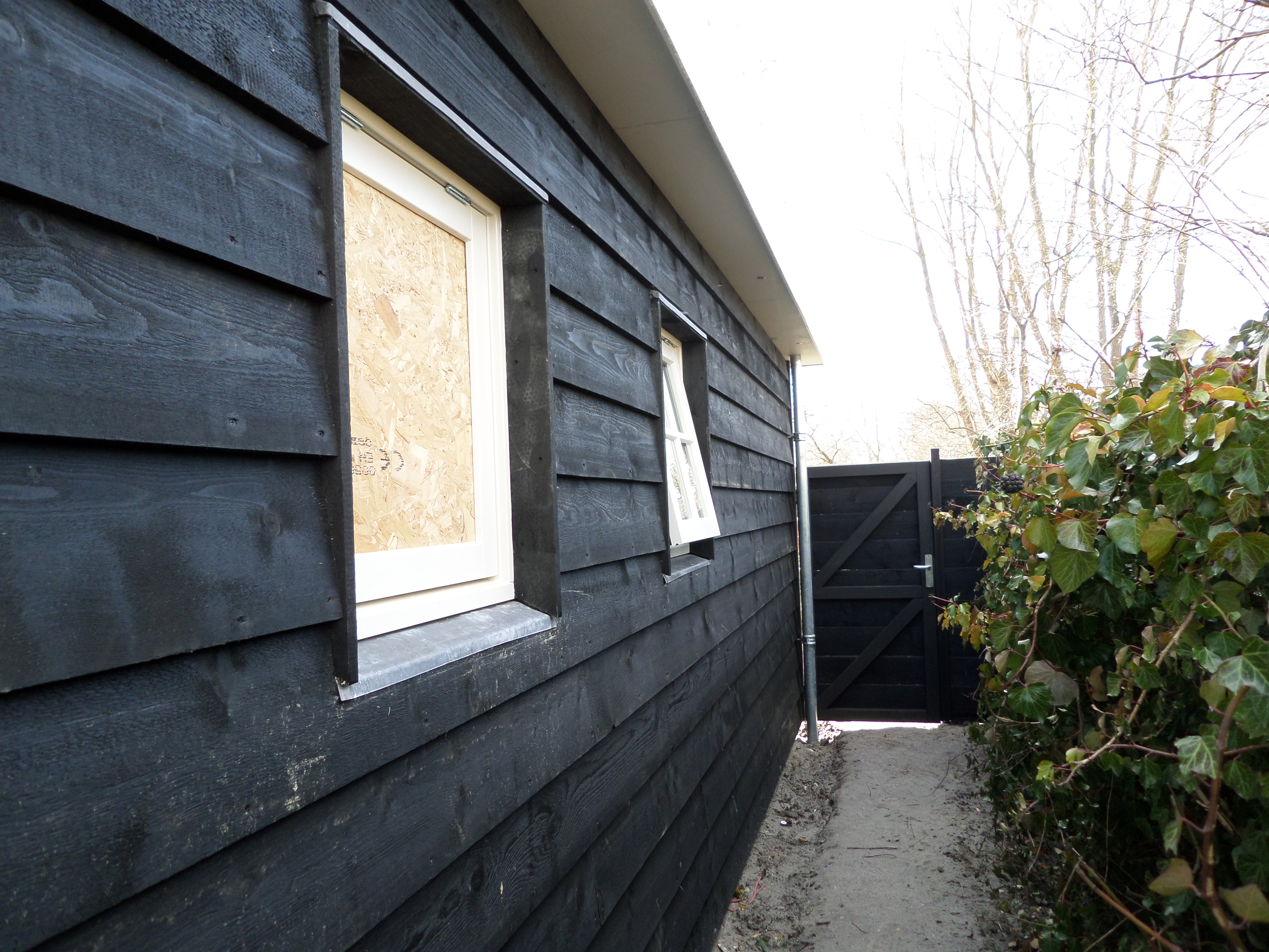 Project: Gevel bekleed met zwart gepotdekselde delen inclusief poort